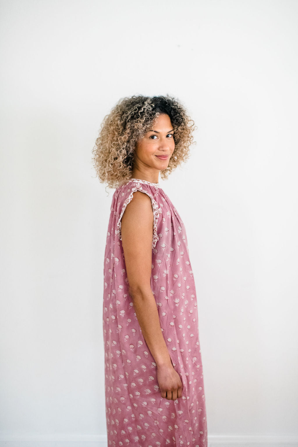 Woman in the Mae Nightgown by Sundara – soft cotton sleepwear with hand-block prints, blending comfort and casual elegance.