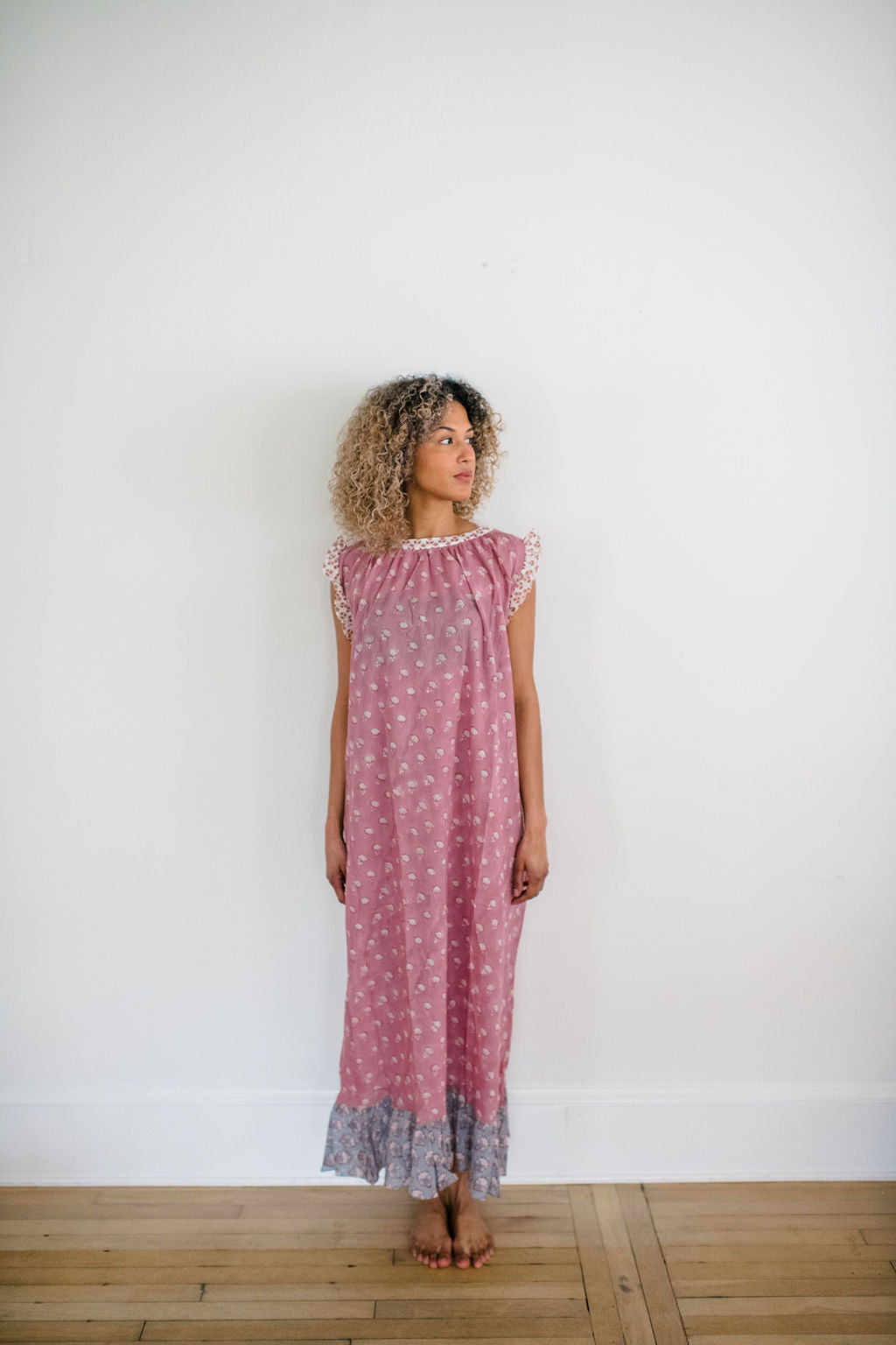 Woman in the Mae Nightgown by Sundara – soft cotton sleepwear with hand-block prints, blending comfort and casual elegance.