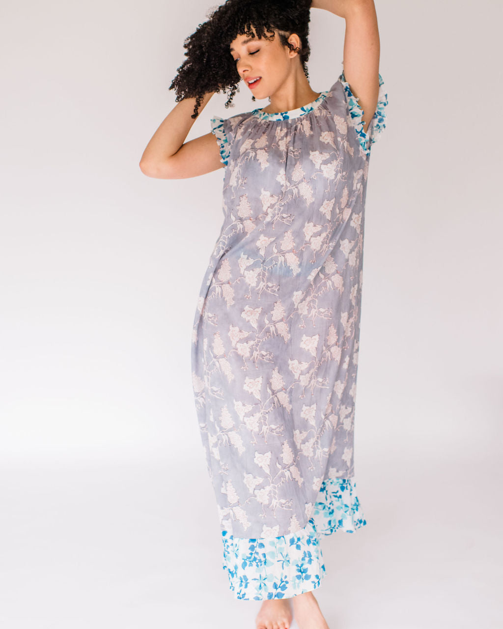 Woman in the Mae Nightgown by Sundara – soft cotton sleepwear with hand-block prints, blending comfort and casual elegance.