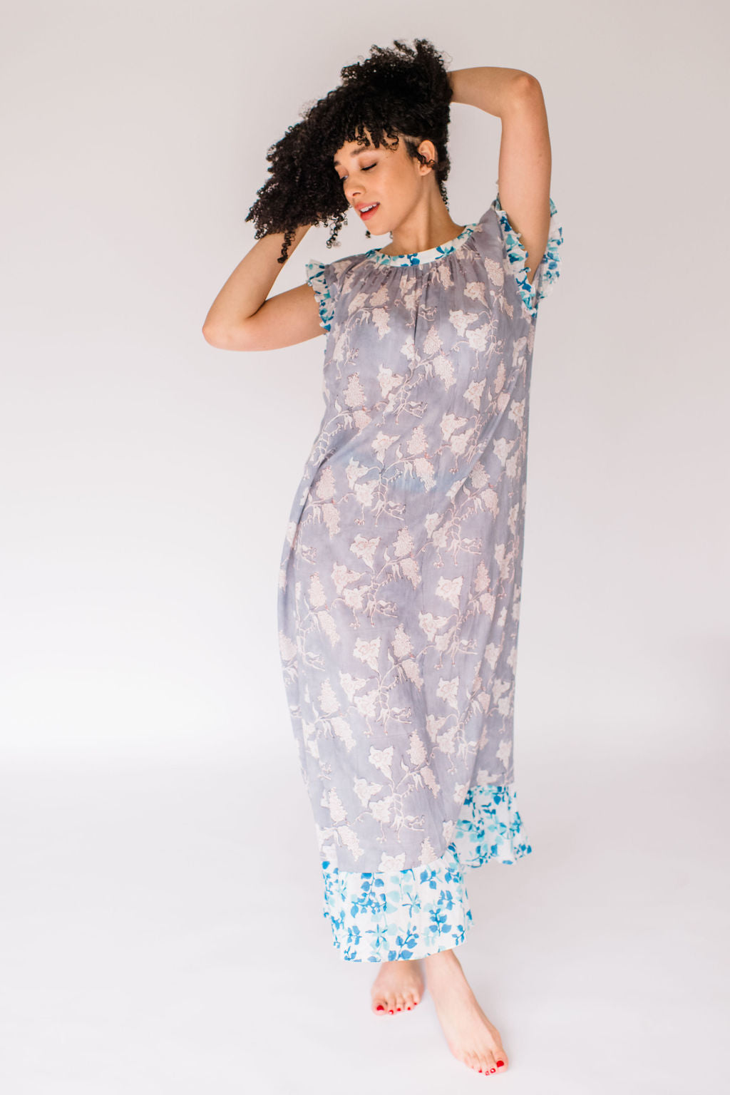 Woman in the Mae Nightgown by Sundara – soft cotton sleepwear with hand-block prints, blending comfort and casual elegance.