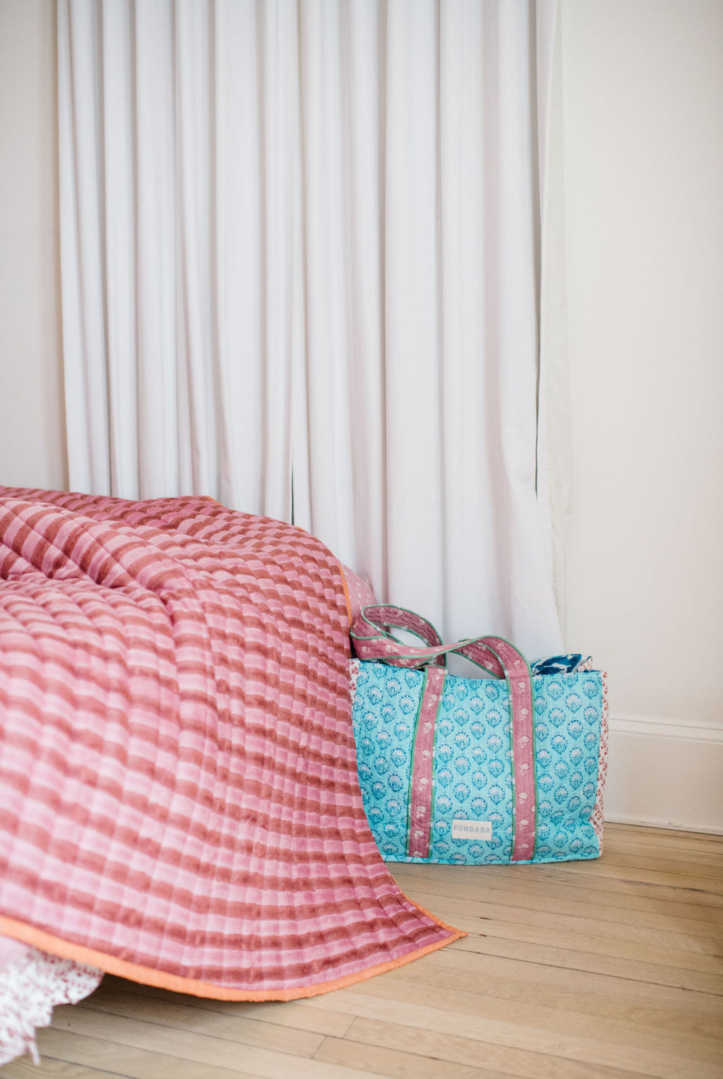 Sundara’s quilted bedding set on a bed, paired with the signature quilted tote bag – combining comfort and style for a cozy, elevated home aesthetic