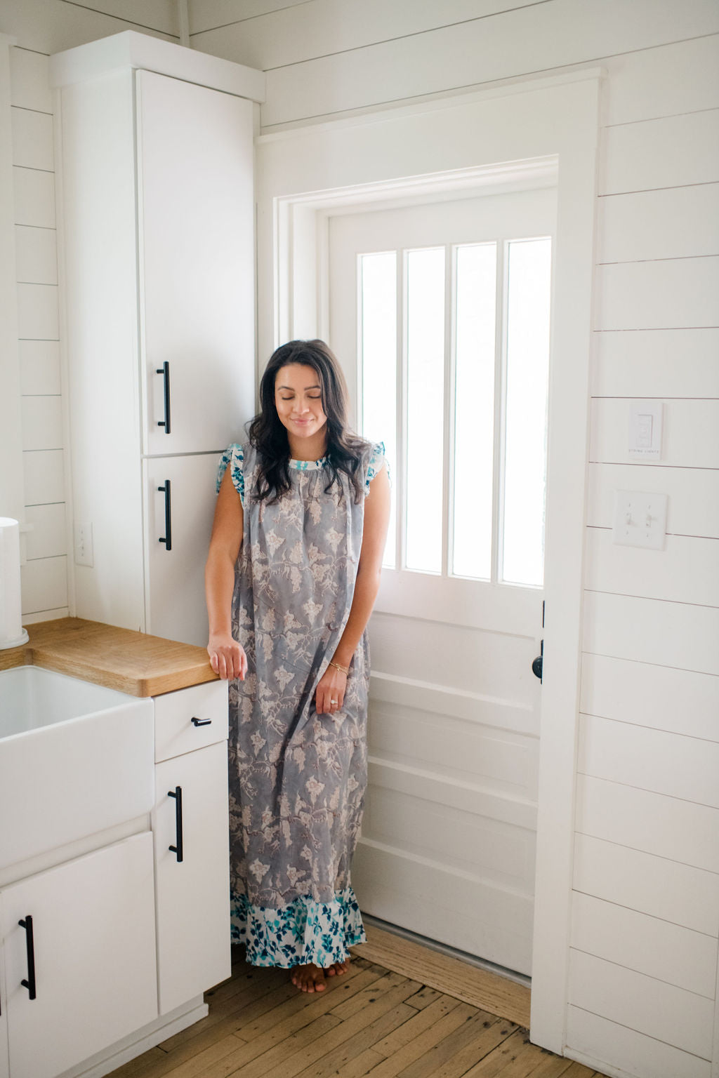 Woman standing in a kitchen wearing the Mae Nightgown by Sundara – a flowy, hand-block printed cotton nightgown perfect for slow mornings and everyday comfort