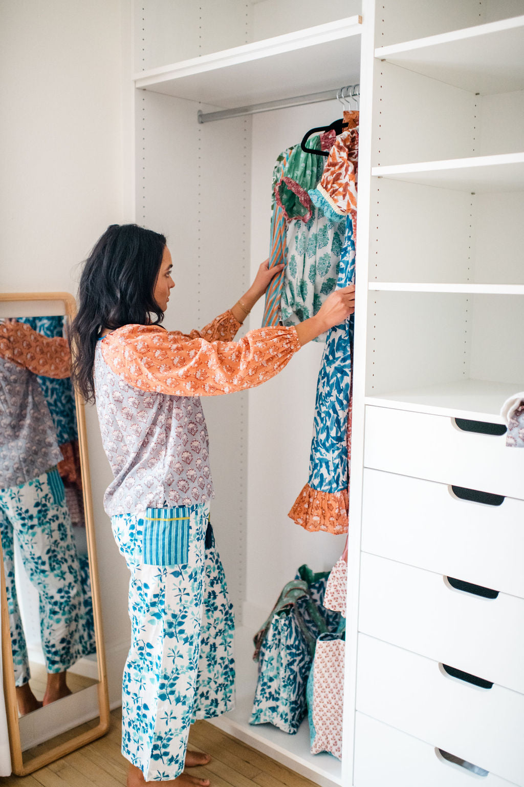 Model hanging Sundara block-printed pajamas in a closet – showcasing soft cotton sleepwear and intentional, slow-living style