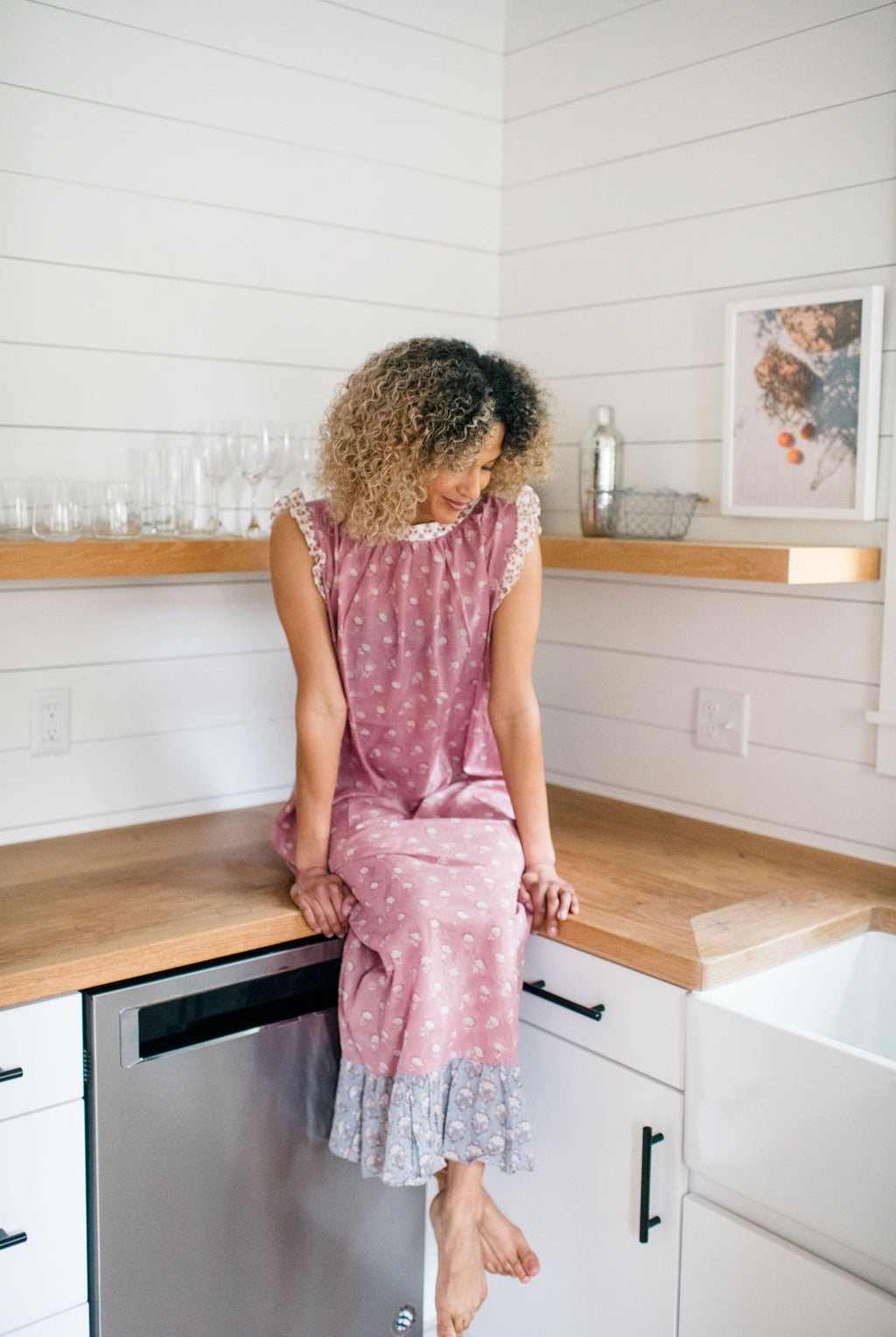 Woman sitting on a kitchen counter in the Mae Nightgown by Sundara – soft cotton sleepwear with hand-block prints, blending comfort and casual elegance.