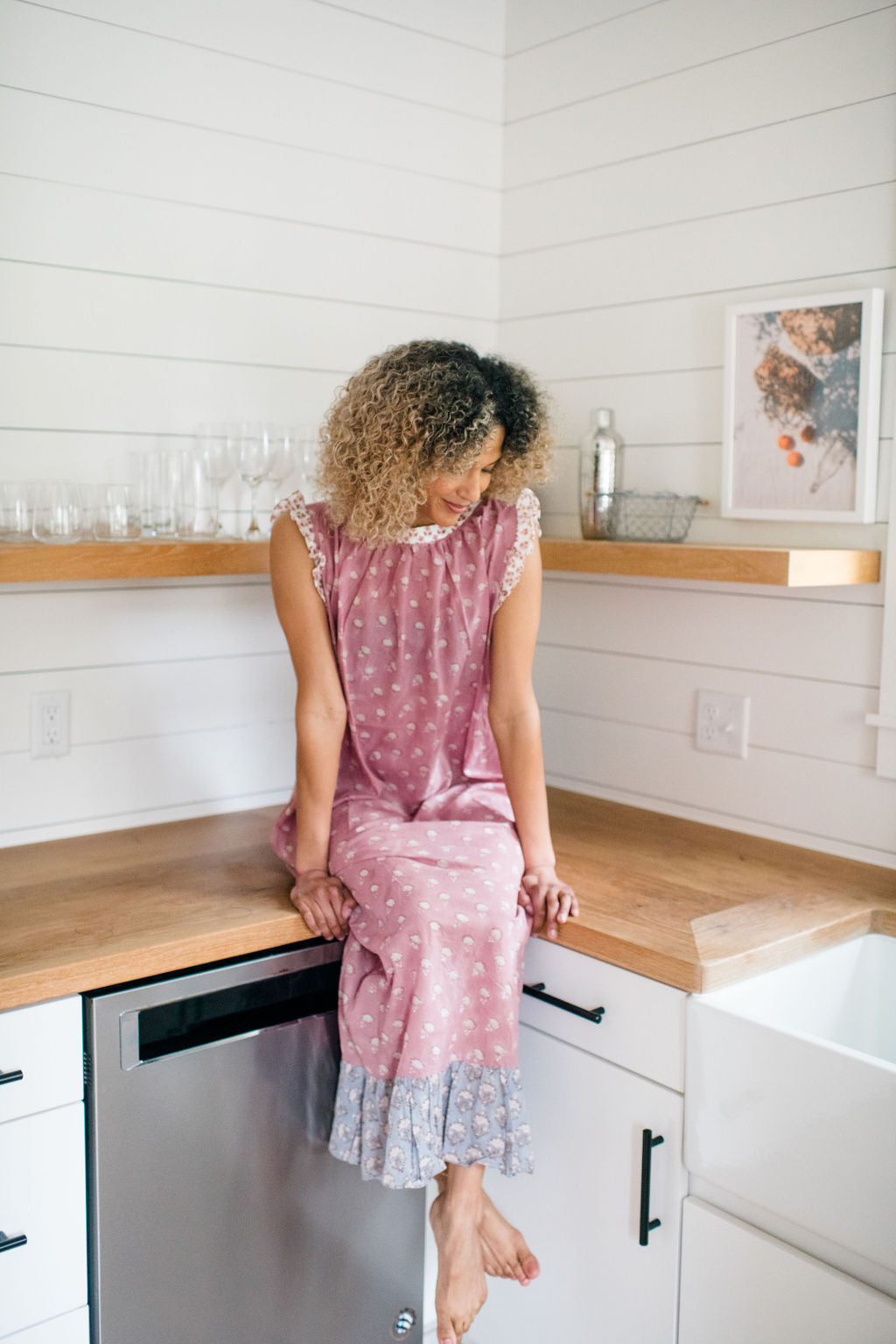Woman sitting on a kitchen counter in the Mae Nightgown by Sundara – soft cotton sleepwear with hand-block prints, blending comfort and casual elegance.