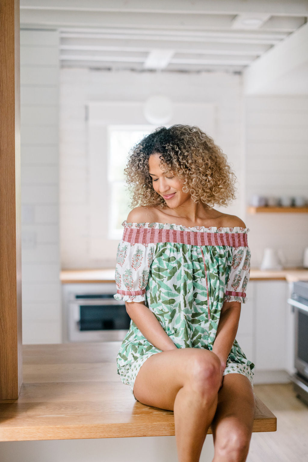 Woman wearing Winnie pajama top in a kitchen