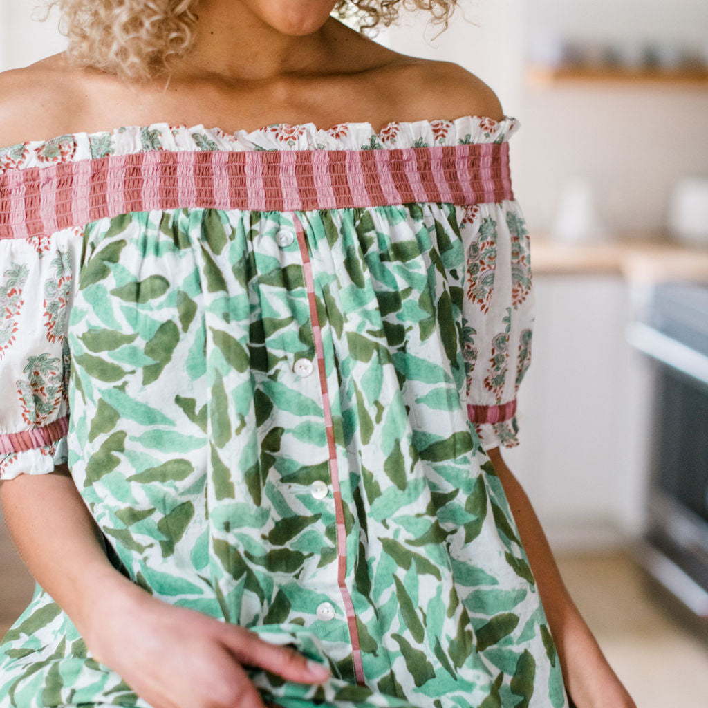 A woman wearing The Winnie Top by Sundara – a relaxed cotton pajama top with off-the-shoulder styling, featuring delicate hand-block prints for a laid-back, stylish look.