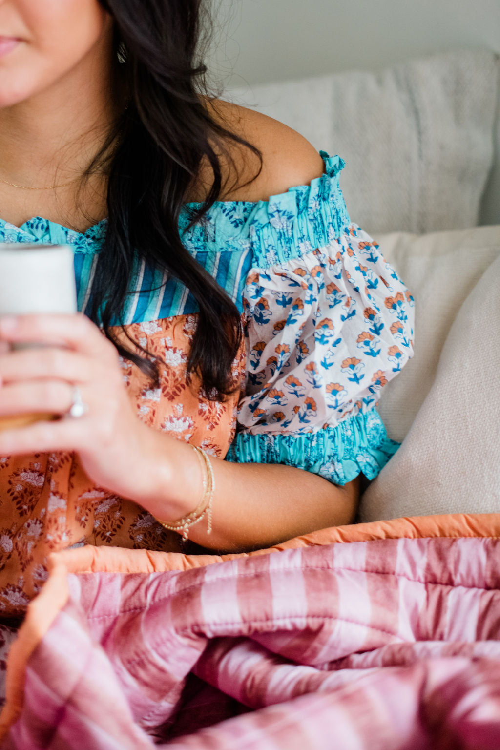 Close-up of the Winnie Top by Sundara – a soft cotton pajama top with delicate block prints, paired with a luxurious quilt for added comfort and style